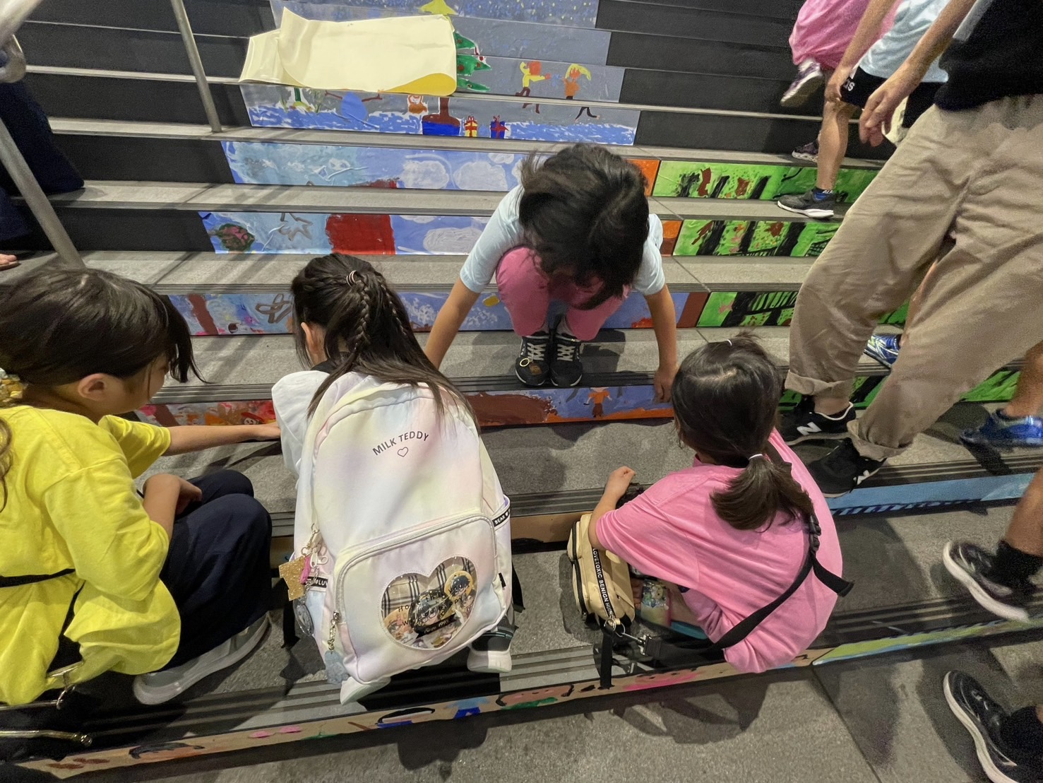 子どもたちが階段に絵を貼っている様子